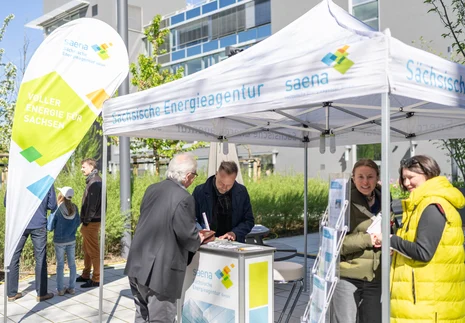 Besucherinnen und Besucher an einem Stand der Sächsischen Energieagentur saena