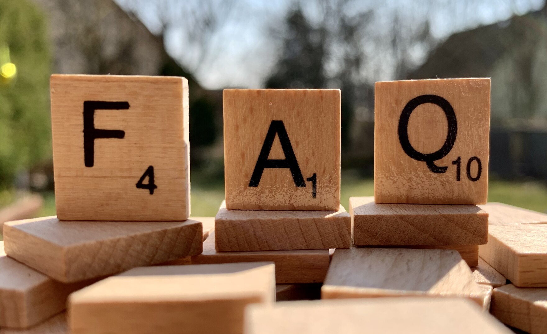 "FAQ" mit Holz-Buchstaben gelegt