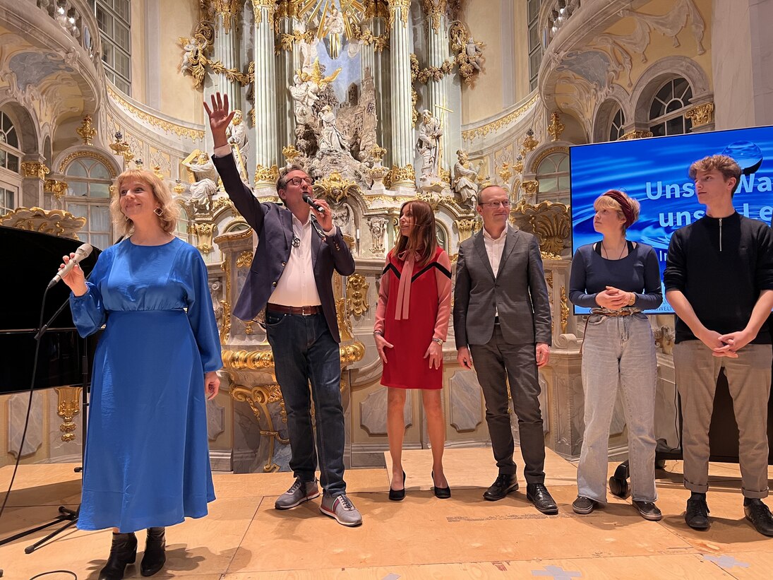 Die Akteure zum Aktionstag »Unser Wasser – unser Leben« stehen auf der Bühne in der Frauenkirche